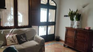 een woonkamer met een bank en een houten deur bij La Casa di Clo in Catania