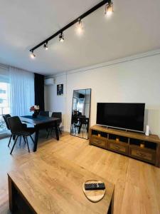 uma sala de estar com uma televisão de ecrã plano e uma mesa em Apartament spațios zona buna em Cluj-Napoca