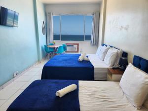 a hotel room with two beds and a window at Apto com Vista total da Praia de Copacabana TC802 in Rio de Janeiro