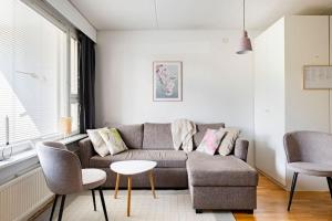 sala de estar con sofá, sillas y mesa en Yksiö saunalla ja patiolla, en Porvoo