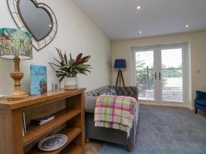 a living room with a couch and a mirror at How Hill Farm Cottage in Penrith