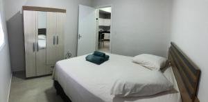 a bedroom with a bed with a blue towel on it at Casa térrea para família no centro de Ametista! in Ametista do Sul