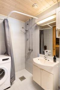 ein Badezimmer mit einer Waschmaschine und einem Waschbecken in der Unterkunft Yksiö saunalla ja patiolla in Porvoo