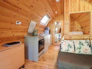 a kitchen in a log cabin with a stove at Homewood Pod in Preston