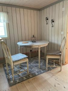 uma mesa velha e duas cadeiras num quarto em Loves Bondgård em Sparreholm