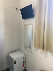 a room with a mirror and a small refrigerator at Pousada Dom Quixote in Arraial d'Ajuda