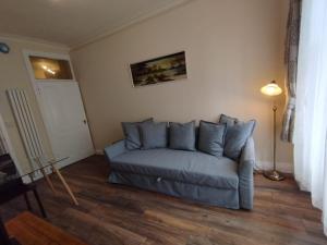 a living room with a blue couch in a room at 2 Bedrooms Flat Central Edinburgh, Sleeps 6, in the shadow of Holyrood Park and Arthur's Seat with free parking, two bed rooms in Edinburgh