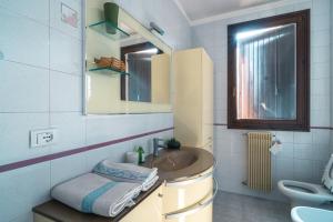 bagno con lavandino e specchio di Te Vojo Ben -Furnished Flat- a Santa Maria di Sala