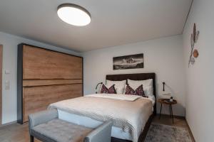 1 dormitorio con 1 cama grande y cabecero de madera en Haus Kulala en Kaprun