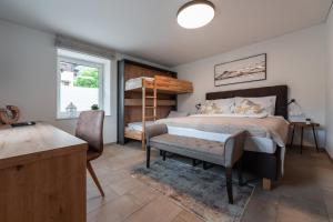a bedroom with a bed and a desk and a chair at Haus Kulala - stilvolle Apartments zwischen Bergen & afrikanischem Flair in Kaprun