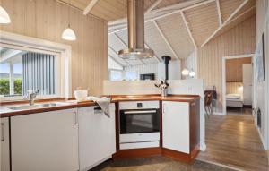 Una cocina con gabinetes blancos y un fregadero. en Holiday Home Sydmarken Hemmet Ii, en Falen