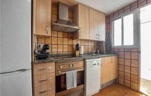 La cuisine est équipée de placards en bois et d'un four avec plaques de cuisson. dans l'établissement Amazing Apartment In El Puig De Santa Maria With Kitchen, à La Torre