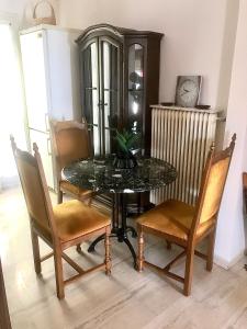 a dining room with a table and chairs and a clock at Carolos‘ house in Kavala