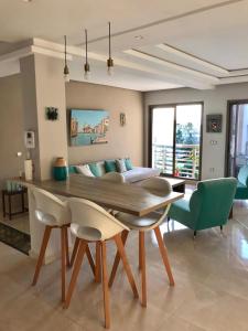 un soggiorno con tavolo, sedie e divano di Bouznika plage costa a Bouznika