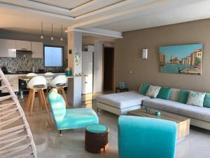 een woonkamer met een bank en een tafel en een keuken bij Bouznika plage costa in Bouznika