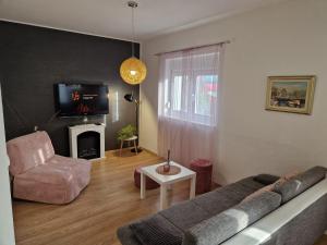 sala de estar con sofá, silla y TV en Apartment Dome, en Biograd na Moru