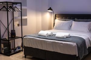 a bedroom with a bed with two towels on it at Black Suites in Chania
