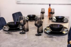 a table with wine glasses and plates on it at Black Suites in Chania +28 photos
