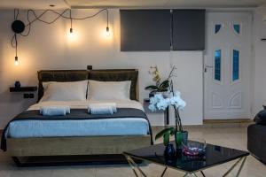 Schlafzimmer mit einem Bett und einem Couchtisch in der Unterkunft Black Suites in Chania