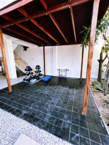 Habitación con suelo de piedra y techo de madera. en Hotel Villa Maria Uribia, en Uribia