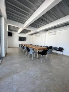 una gran sala de conferencias con mesa de madera y sillas en Hotel Villa Maria Uribia, en Uribia