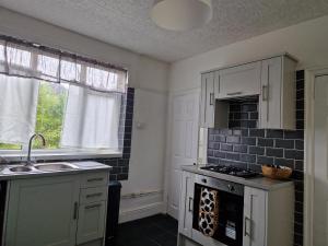 a kitchen with a sink and a stove top oven at Therence Accommodations can sleep up to 4 Guests in Chesterton, Stoke on Trent in Longport