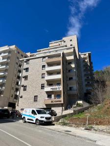 a white car parked in front of a building at Apartman darko in Becici