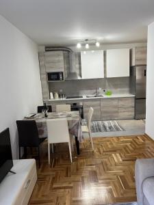 - une cuisine avec une table et des chaises dans la chambre dans l'établissement Apartman darko, à Becici
