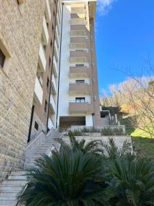 a building with stairs and palm trees in front of it at Apartman darko in Becici +3 photos