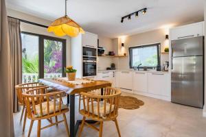 Una cocina con mesa y sillas y un refrigerador. en Villa Verde Luxury Mediterranean Villa With Private Pool, en Kas