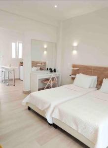 a white bedroom with two beds and a desk at E & G- Figareto Apartments 4 in Corfu Town