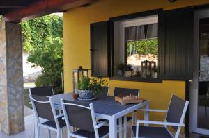 einen Esstisch und Stühle auf einer Terrasse in der Unterkunft KAMENJAK VOLME, Cousy house with Pool in Banjole
