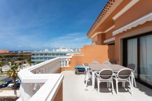 een balkon met een tafel en stoelen in een gebouw bij Exclusive Penthouse Playa Las Vistas 4 close to the sea and beach, aircondition for a fee, wifi, terrace, heated pool in Playa de las Americas