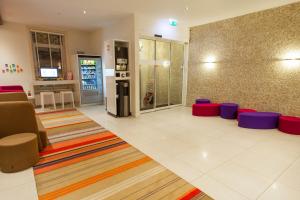 a living room filled with furniture and a tv at ibis Styles Amsterdam Amstel in Amsterdam