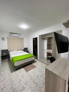 a bedroom with a bed and a flat screen tv at Hotel Villa Maria Uribia in Uribia