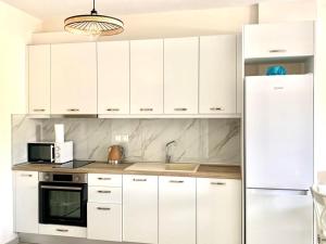 a kitchen with white cabinets and a white refrigerator at Blue Lagoon in Nikiti