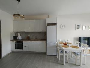 a kitchen with a table and a white refrigerator at Blue Lagoon in Nikiti