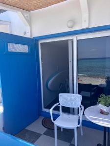 a blue door and a white chair and a table at Aquamarine in Firopótamos