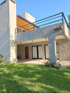 Una casa con un césped verde delante de ella. en TERRA CIMINTO, en Villa Rumipal