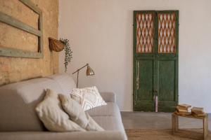 a living room with a couch and a green door at Il Nido in Buonconvento