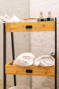 a wooden shelf with towels on it in a bathroom at Twelve Studios in Ioannina