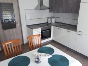 une cuisine avec une table et des chaises et une cuisine avec des placards blancs dans l'établissement Apartma RELAX, à Bertoki
