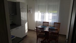 une cuisine avec une table et des chaises et une cuisine avec une fenêtre dans l'établissement Apartma RELAX, à Bertoki
