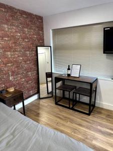 a bedroom with a table and a brick wall at Perfect stay with Dallas Studio in Hayes