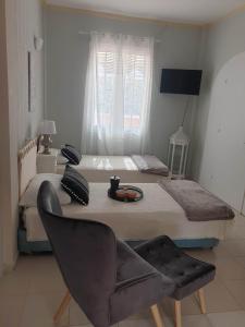 a bedroom with a large bed with a chair and a chair at Villa titika in Argostoli