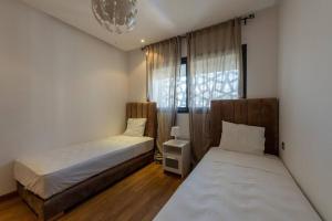 拉巴特Très bel appartement bien situé Hayriad的有两张床和一扇窗户的卧室