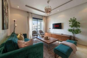 拉巴特Très bel appartement bien situé Hayriad的客厅里有一张绿色的沙发和一张桌子