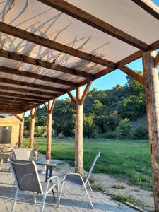 eine Terrasse mit Stühlen und einem Tisch unter einer hölzernen Pergola in der Unterkunft MAD'S Villas in Néa Péramos