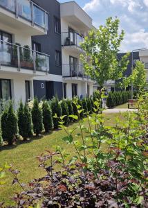 an apartment building with a yard with plants at Apartamenty Parkowe D9 in Oświęcim