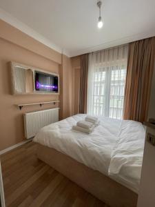 - une chambre avec un lit et des serviettes dans l'établissement Mina Suits, à Istanbul
